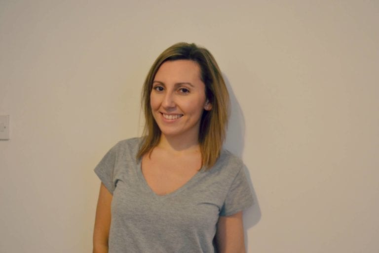 woman wearing grey t-shirt with blondey hair and smiling
