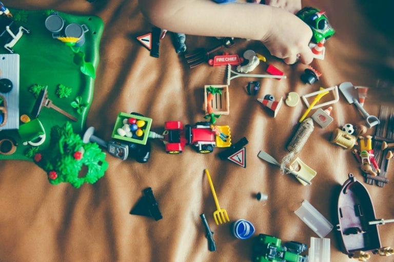 childs arm reaching for toys on floor