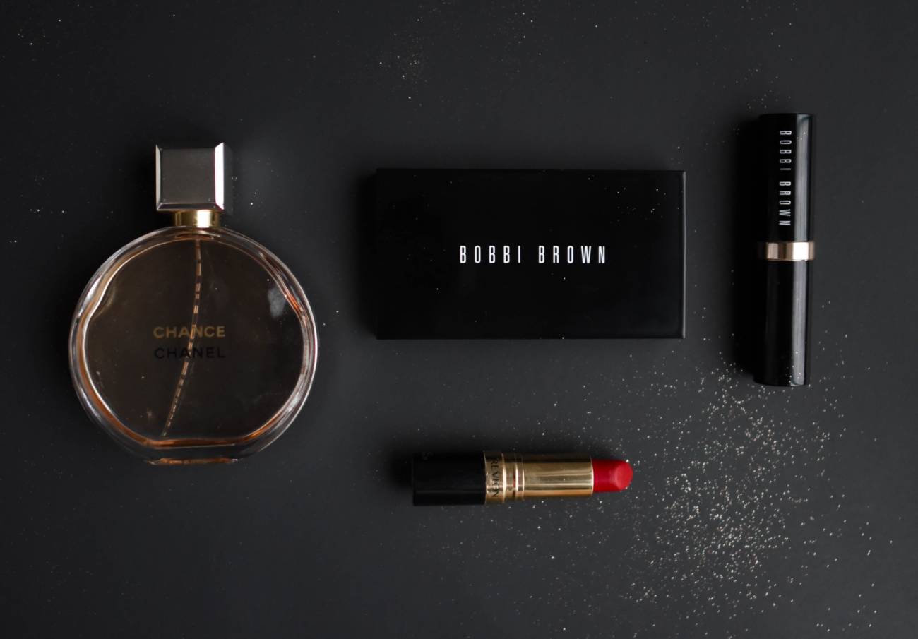makeup products and perfect laid down on dark grey surface