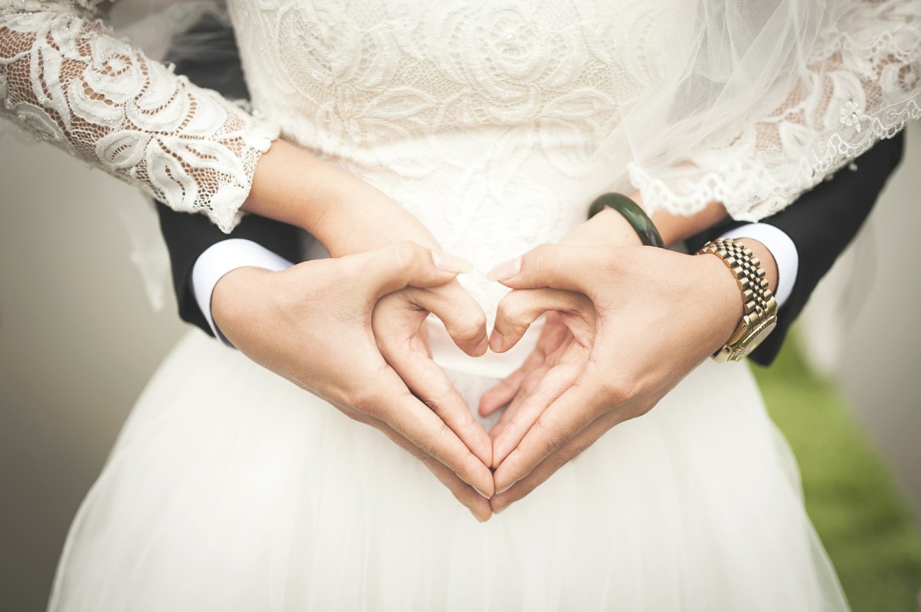 bride and groon making their hands into hearts