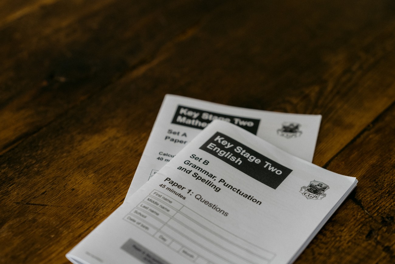 two exam papers on a table, with 'key stage two english' on the top one