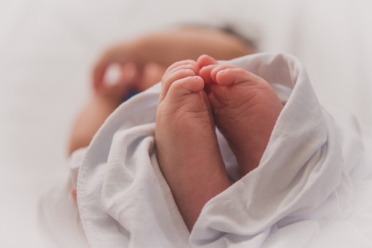 newborn baby in blanket, feet up close to camera
