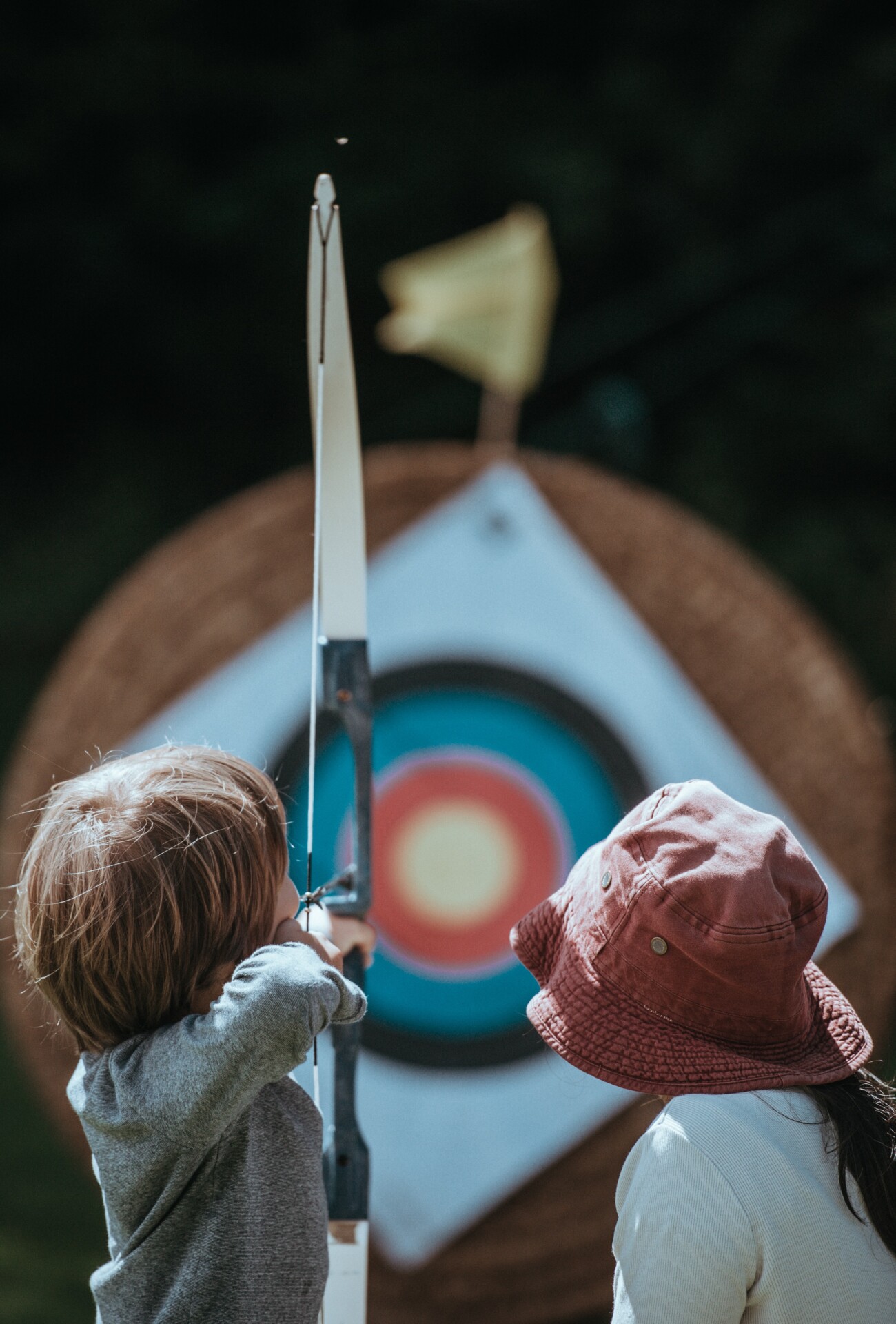 child doing archery with bow and arrow