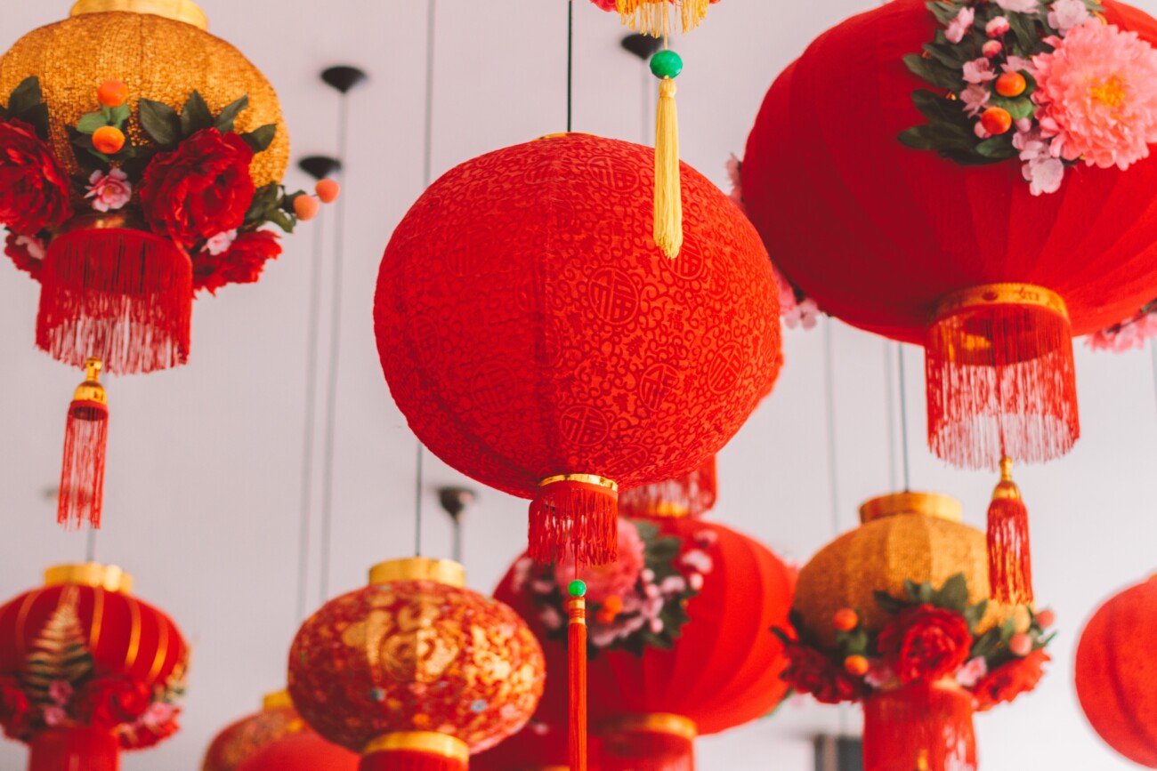 lots of red and orange chinese lanterns hanging on ceiling
