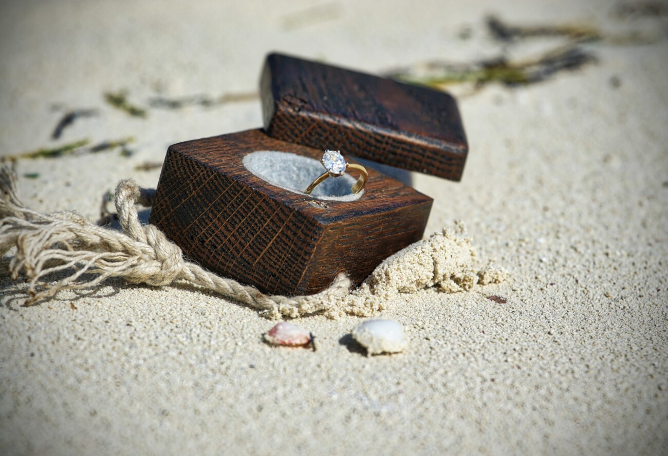 engagement ring in box on the sand