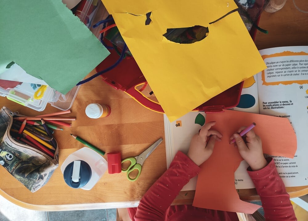 aerial view of child doing arts and crafts on table
