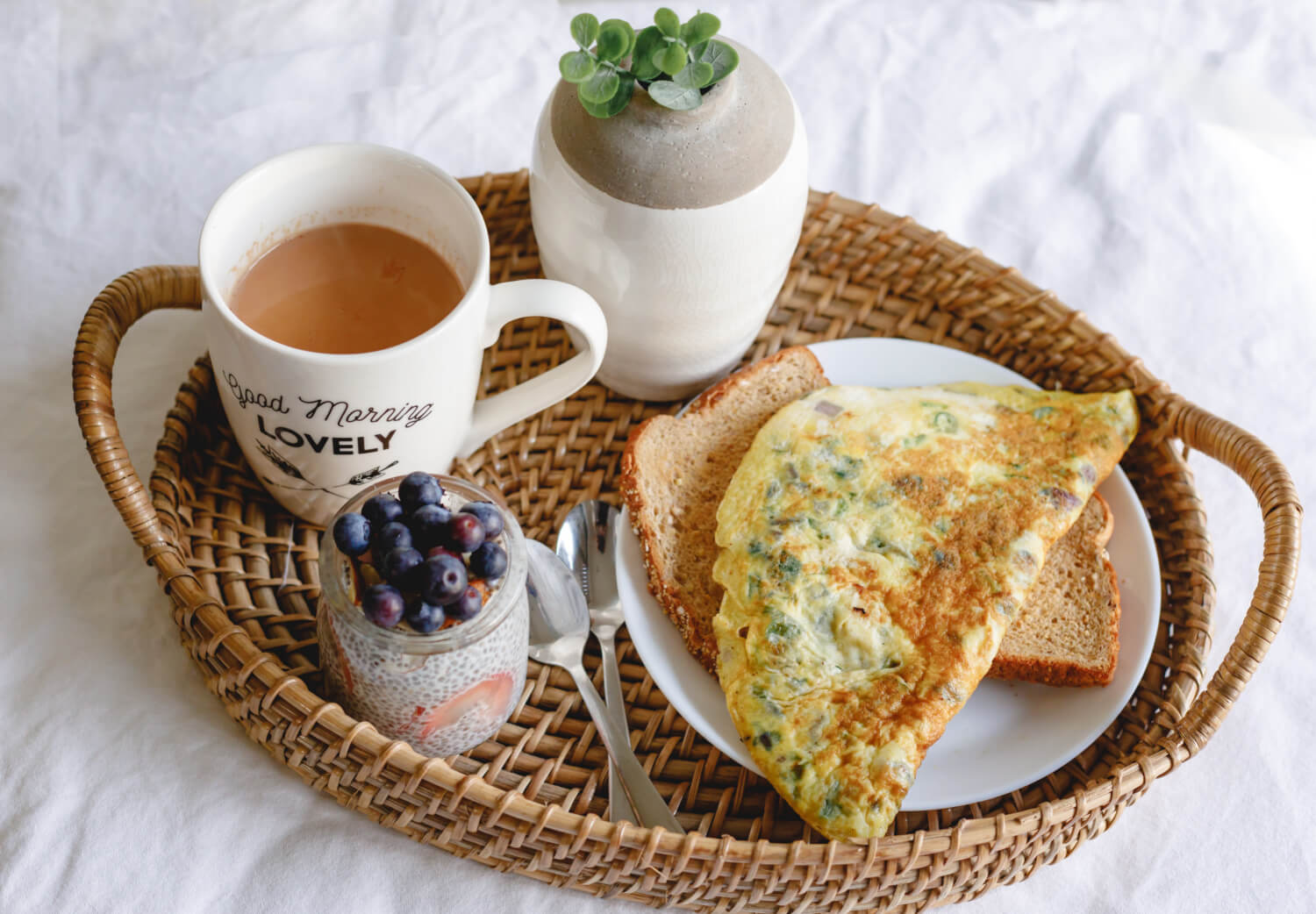 tray with breakfast on and cup of tea with plant