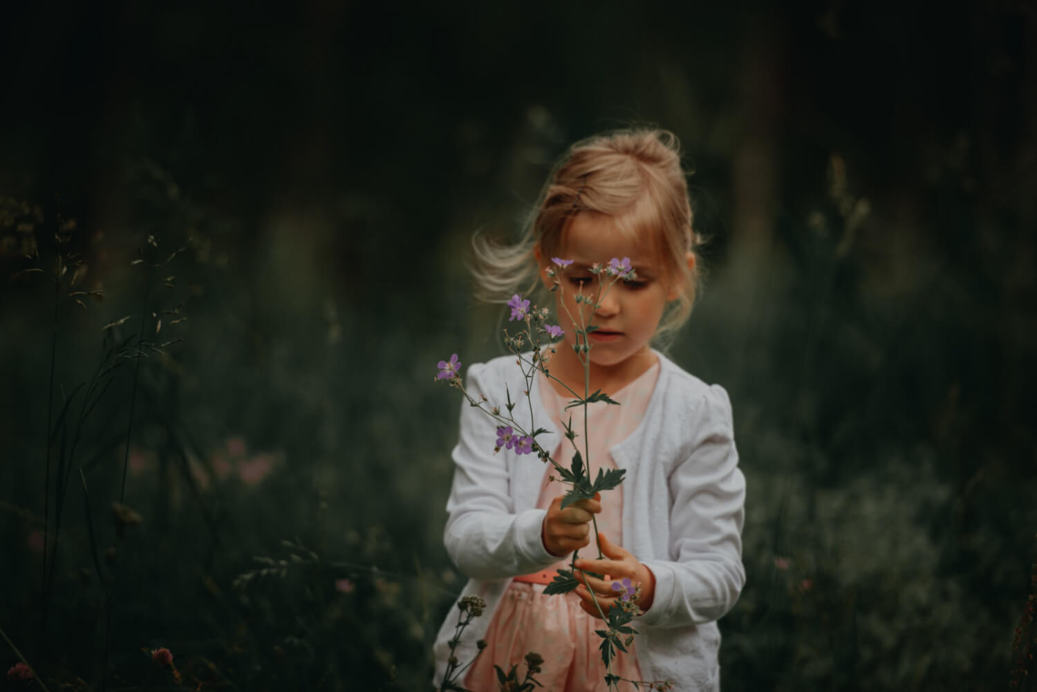 young girl outside, holding flower