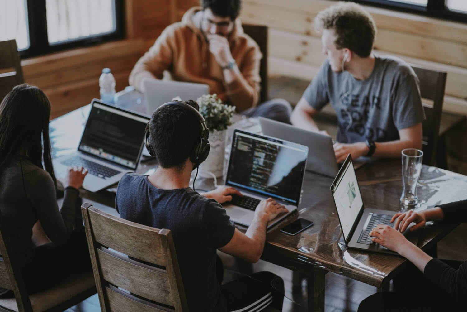 people working around a desk at laptops