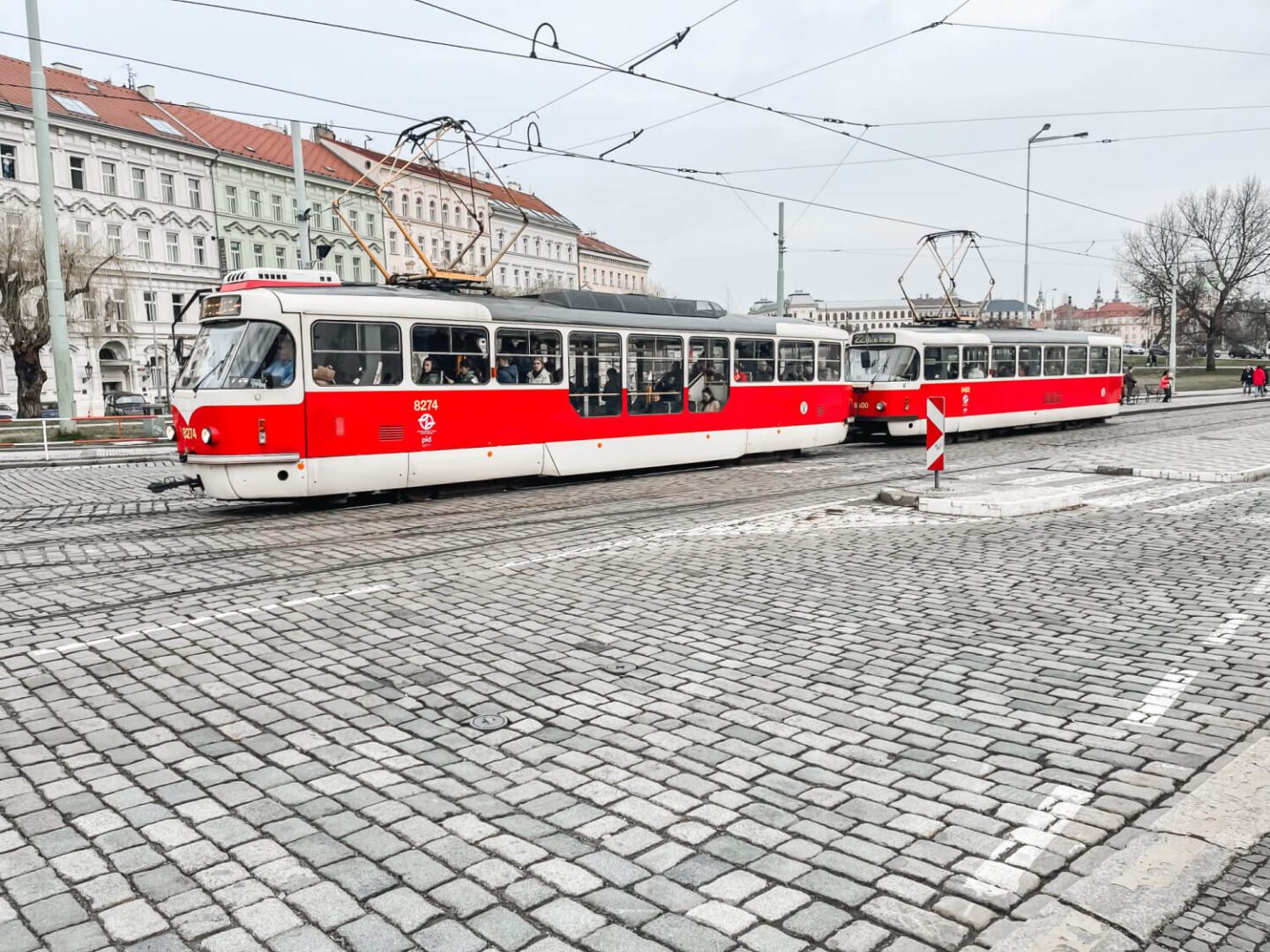 red and white tram on cobbled street