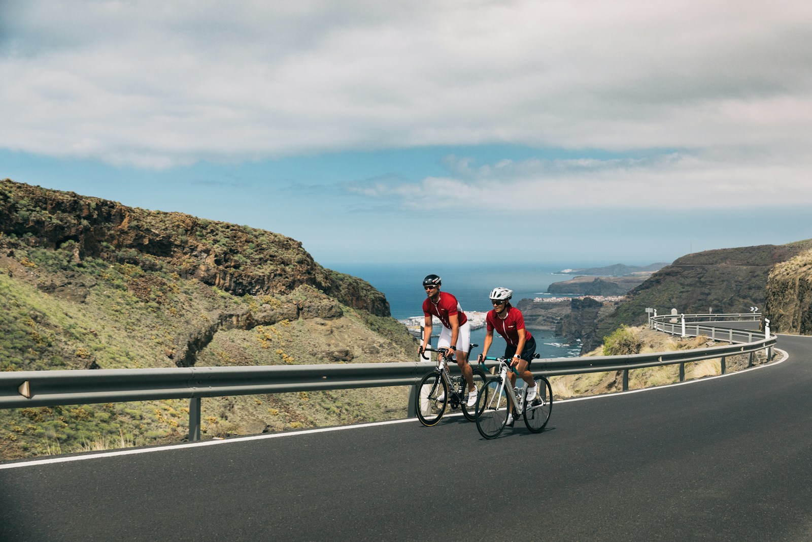 man and woman on bikes cycling up a hilly road