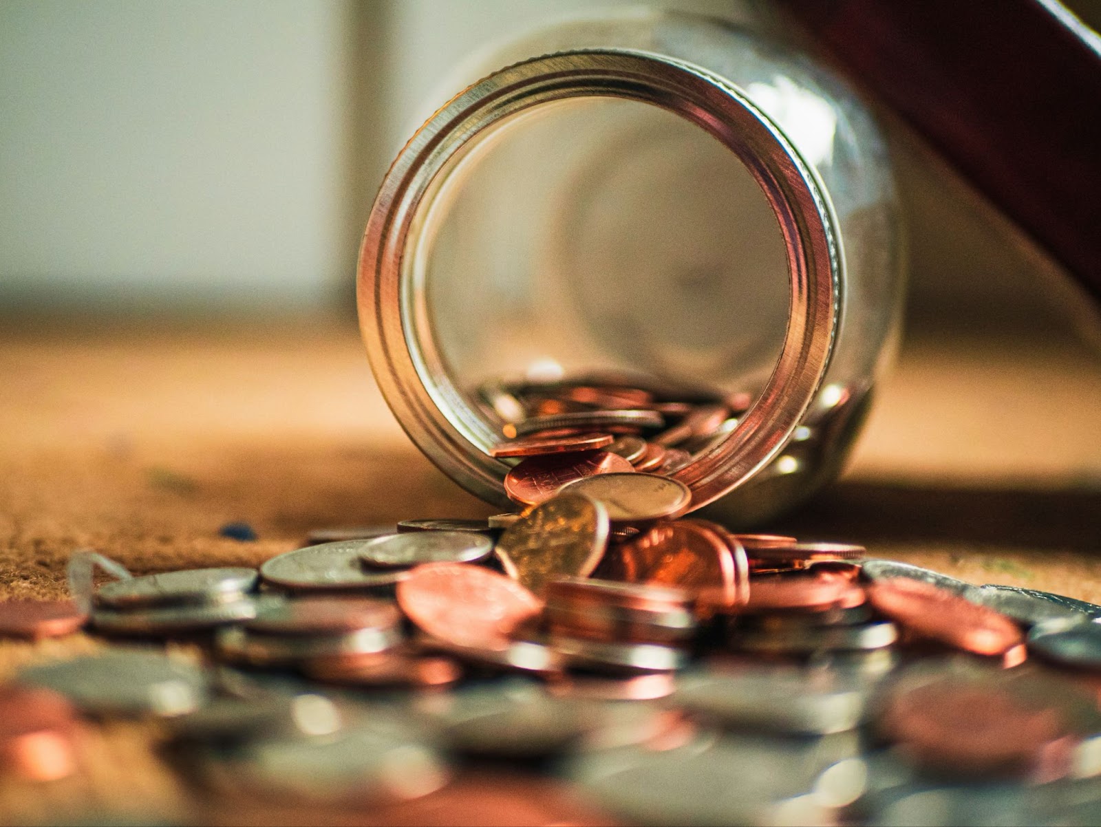 coins spilling out glass pot