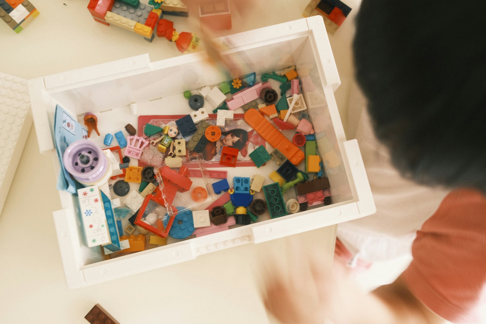 a child is playing with a box of lego