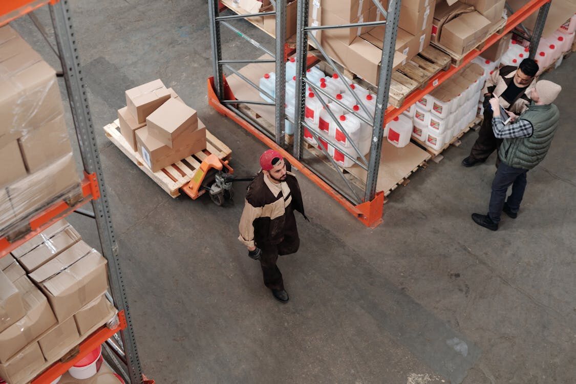 man pulling crate in warehouse from above