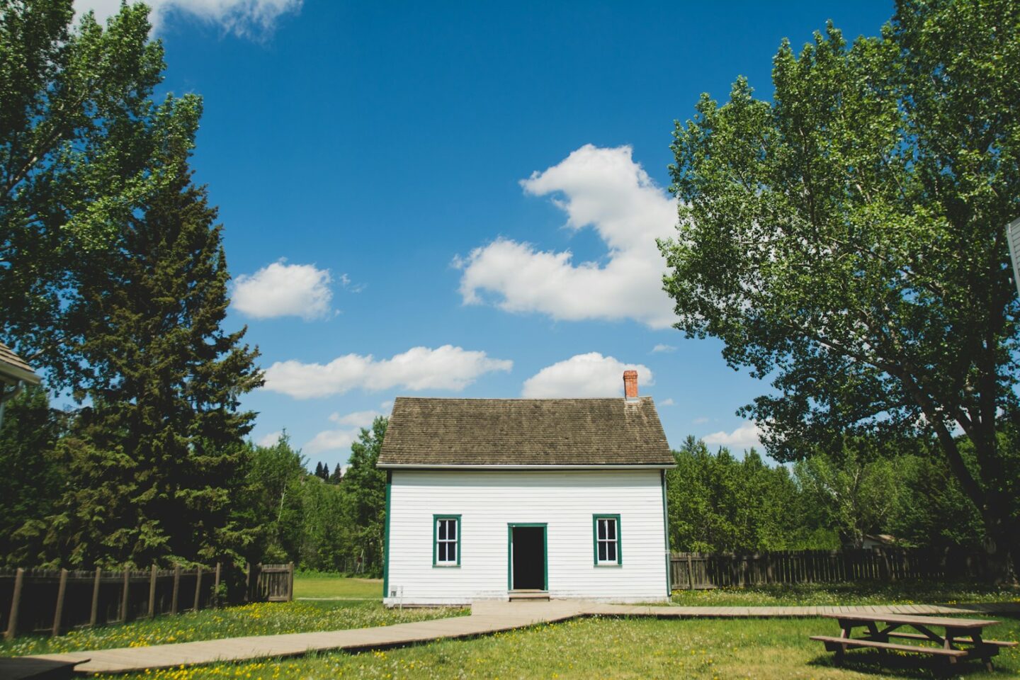 small white house with paths between trees