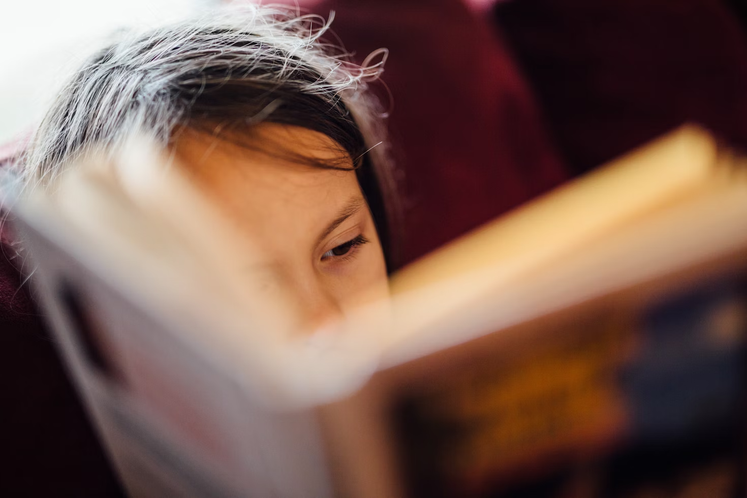 child reading book up close to face