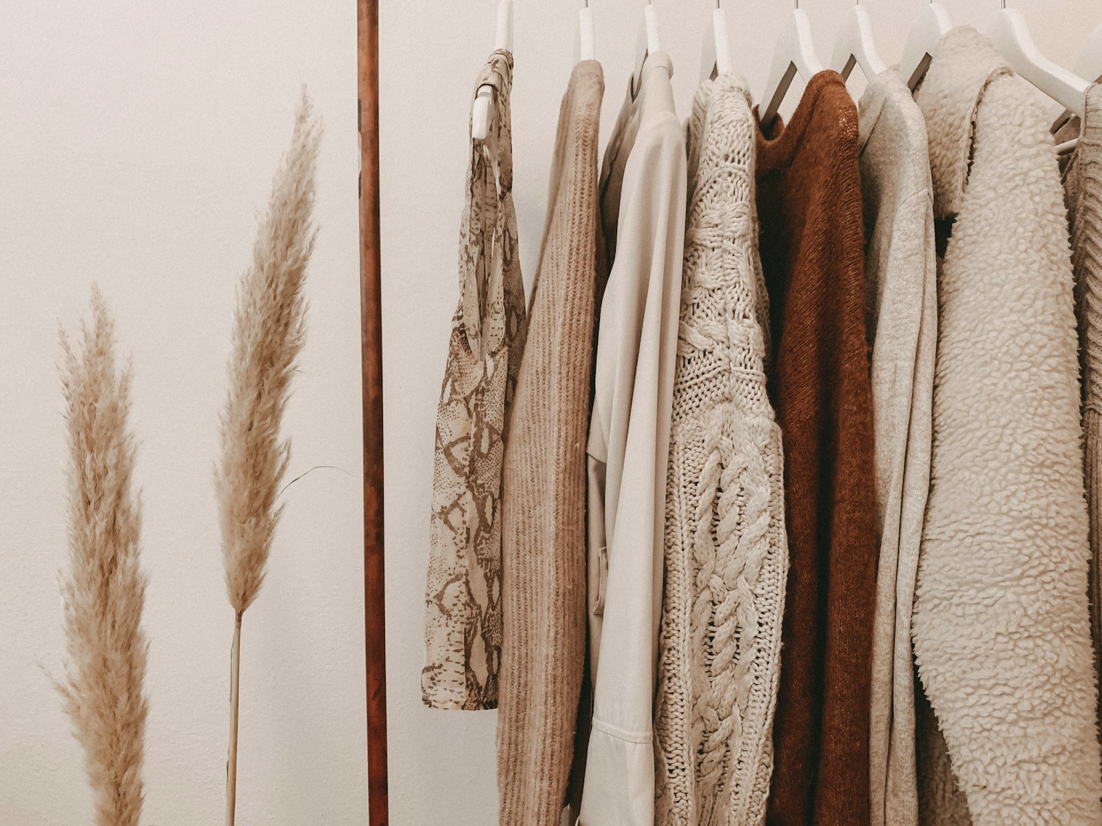 hanging neutral-toned clothes hanging on open wardrobe
