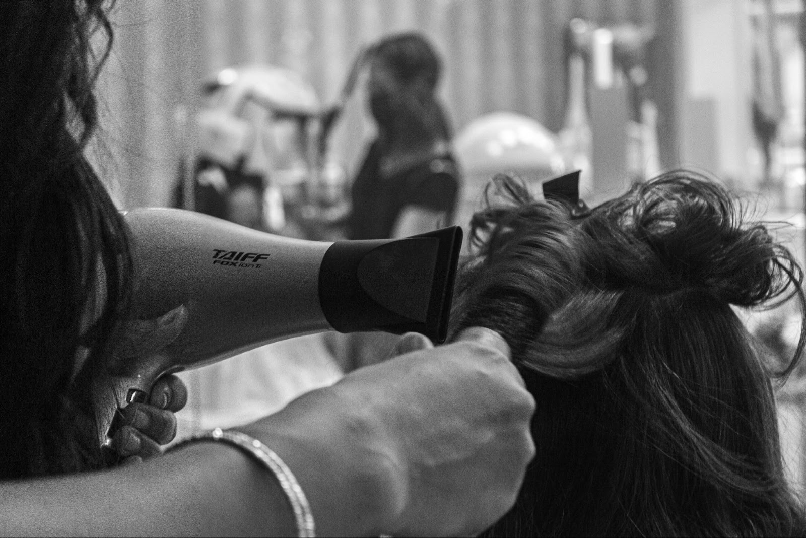 hands holding hairdryer, blowdrying customers hair