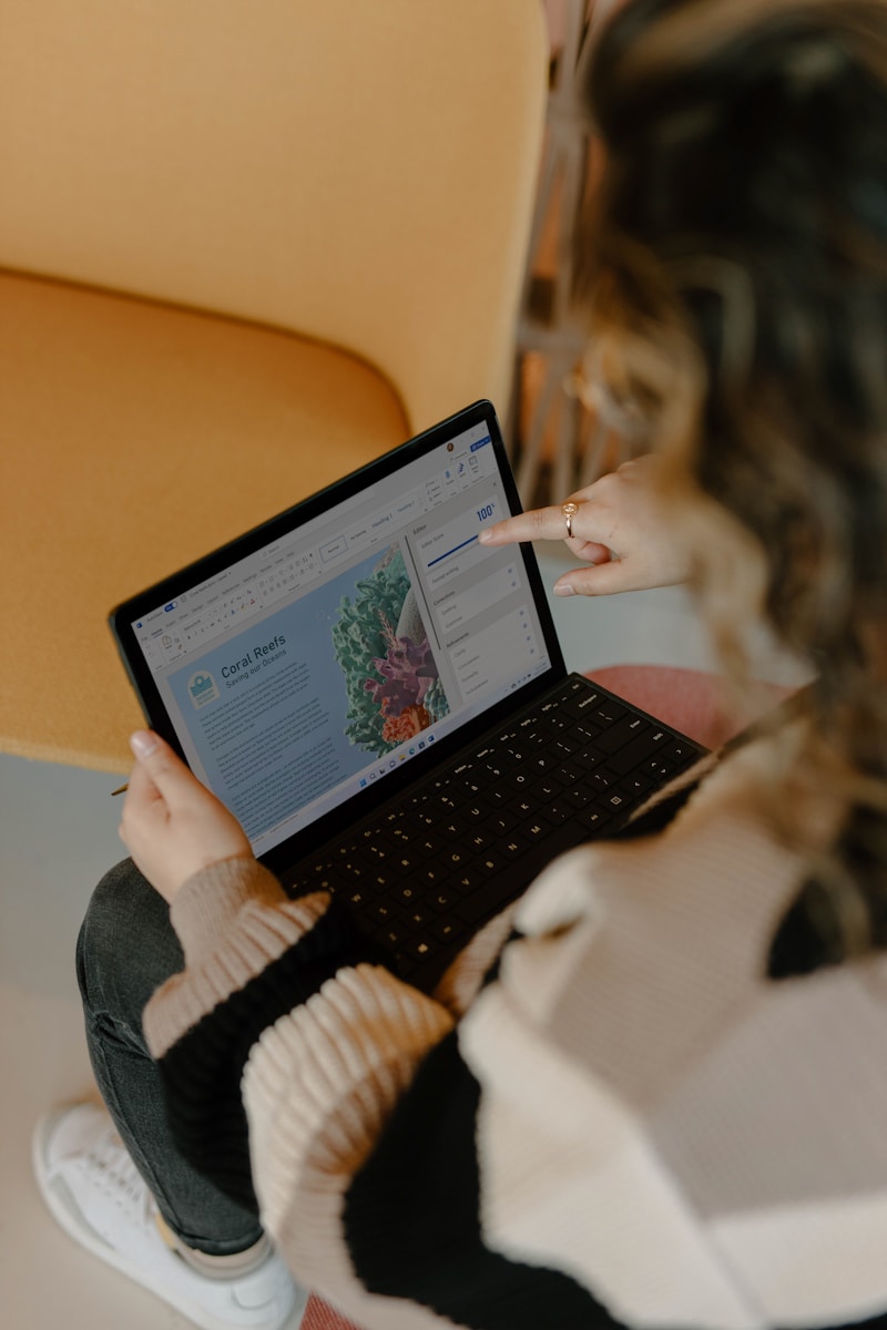 a person using a laptop with hand on screen