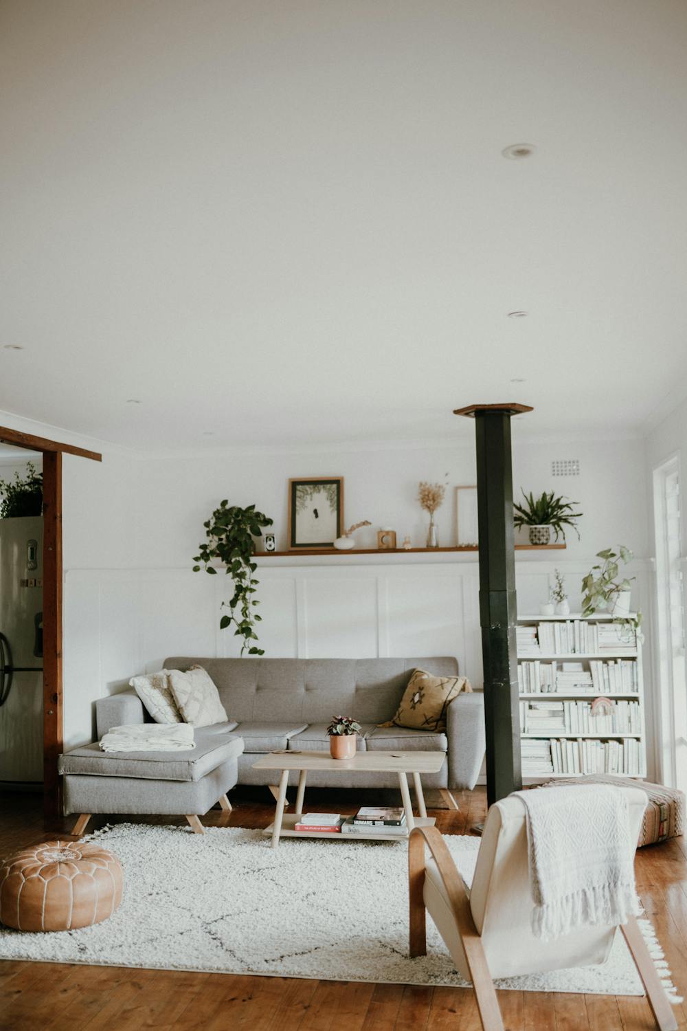lounge with grey corner sofa, plants, books on bookshelves