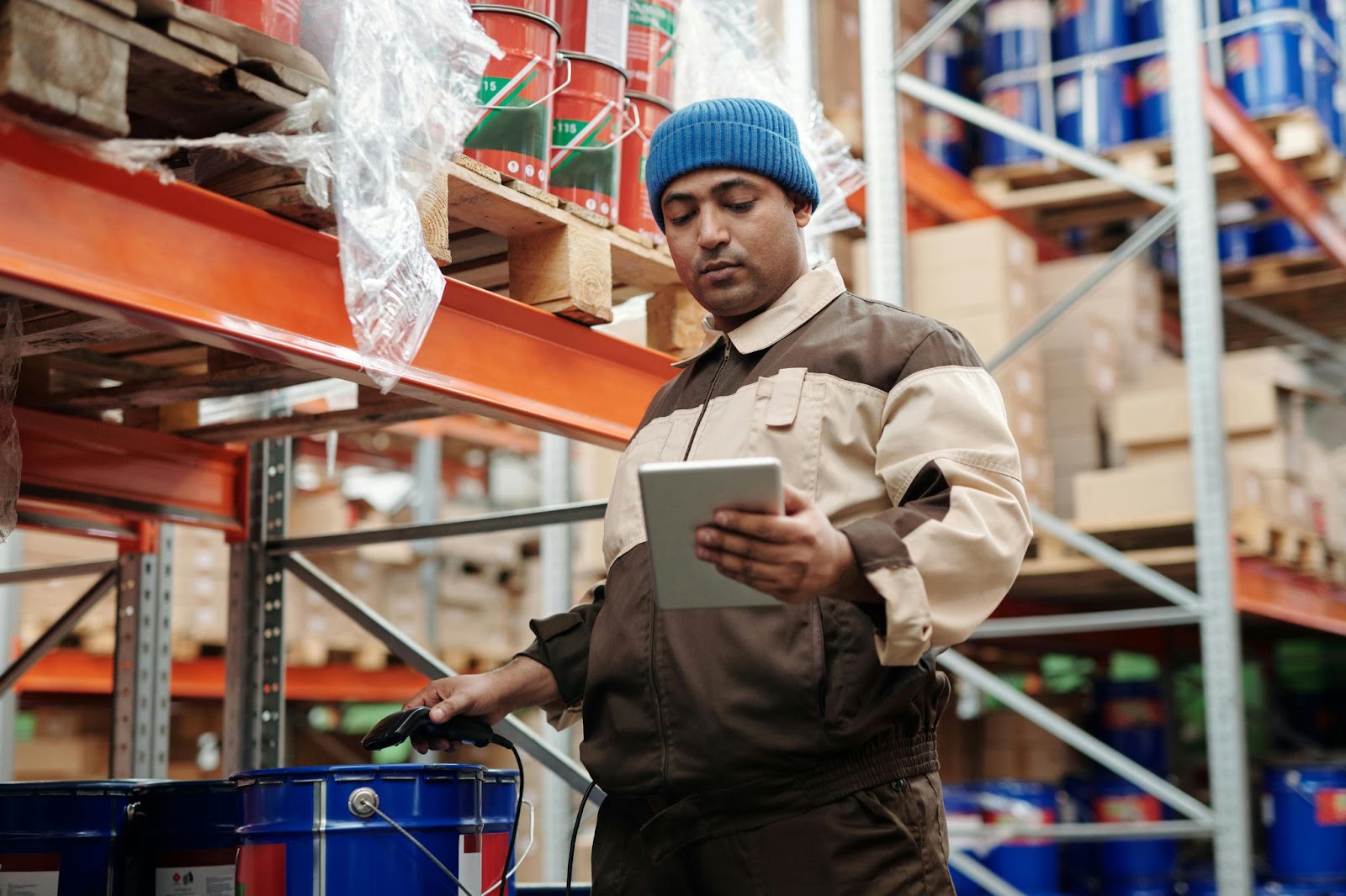 man in warehouse looking at pad in hand
