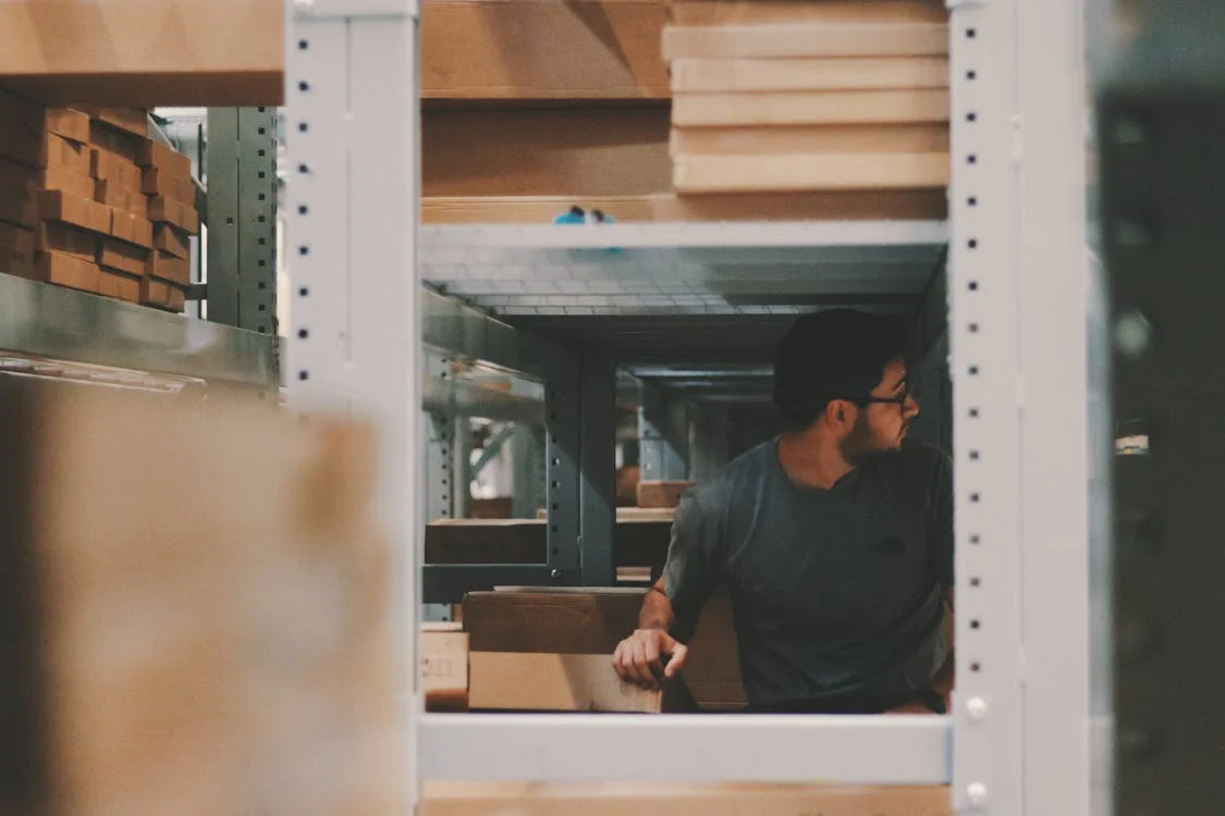 man in warehouse under shelving
