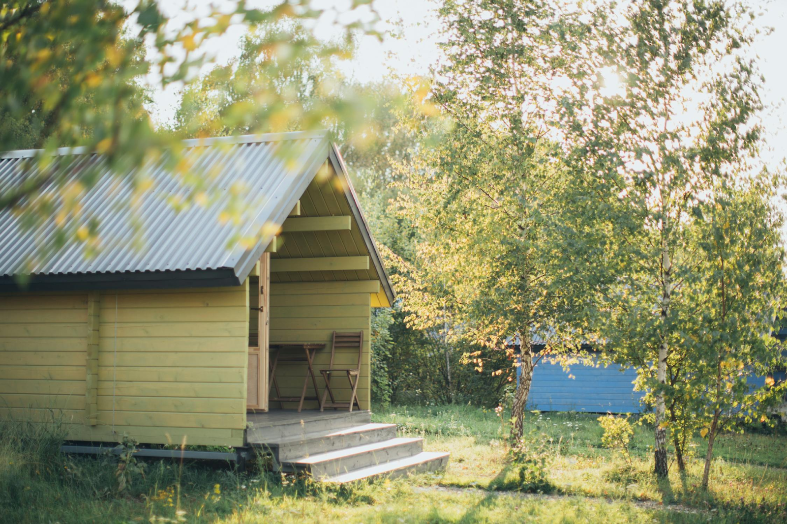 large yellow wooden summer house in garden