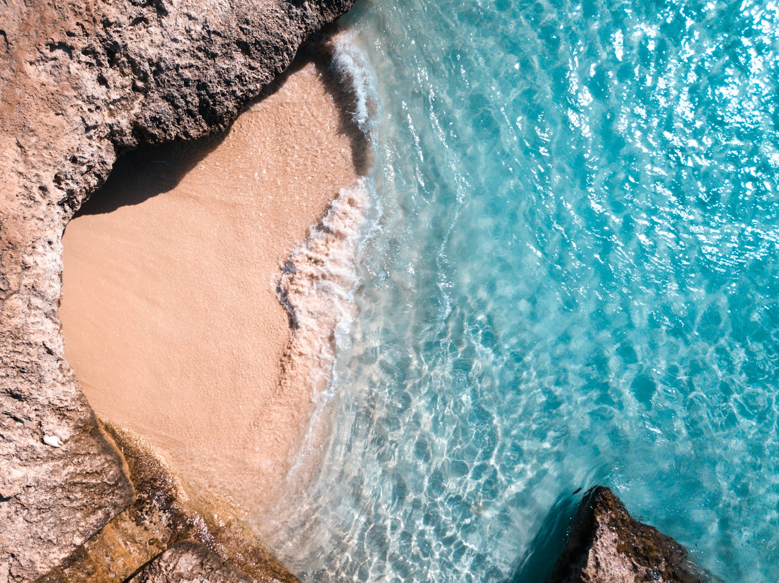 aerial view of ocean waves crashing on shore during daytime