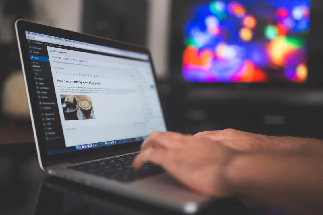person's hands typing on laptop