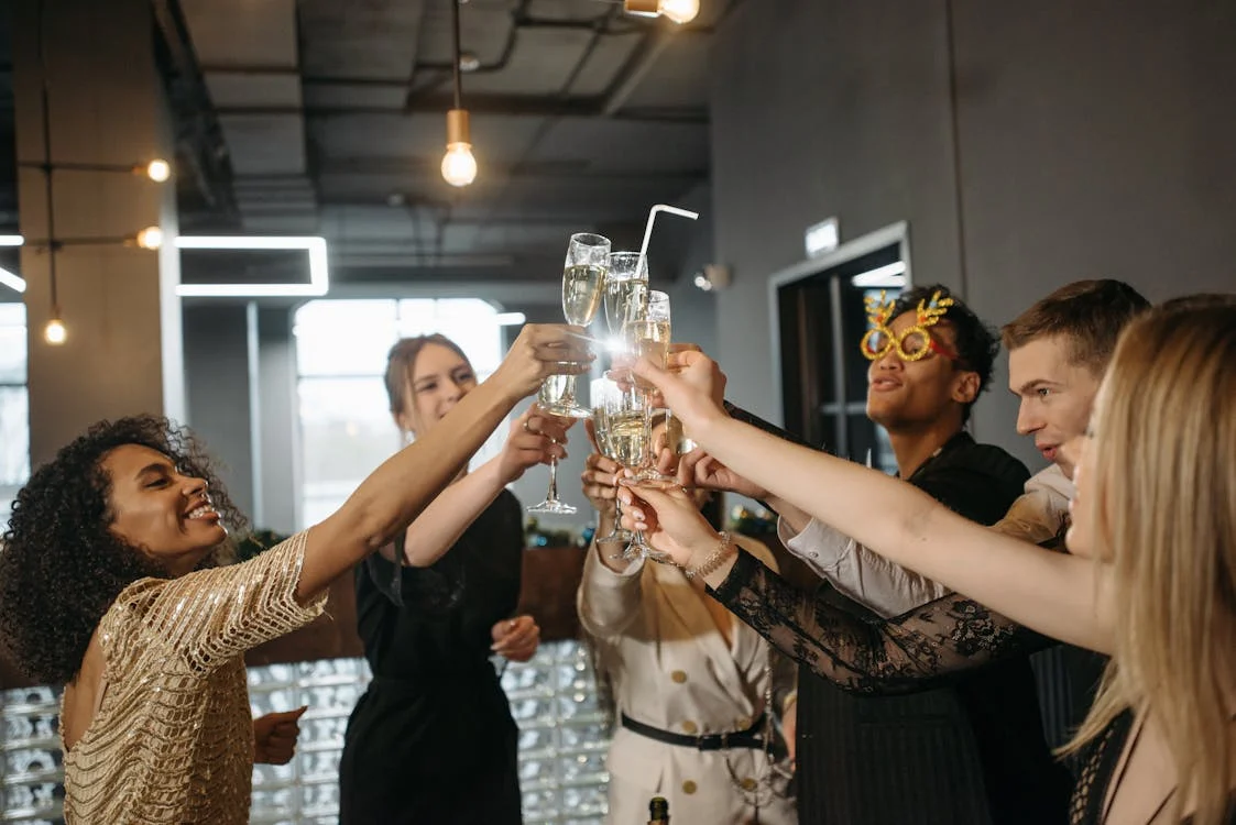 group of people in bar raising their glasses together