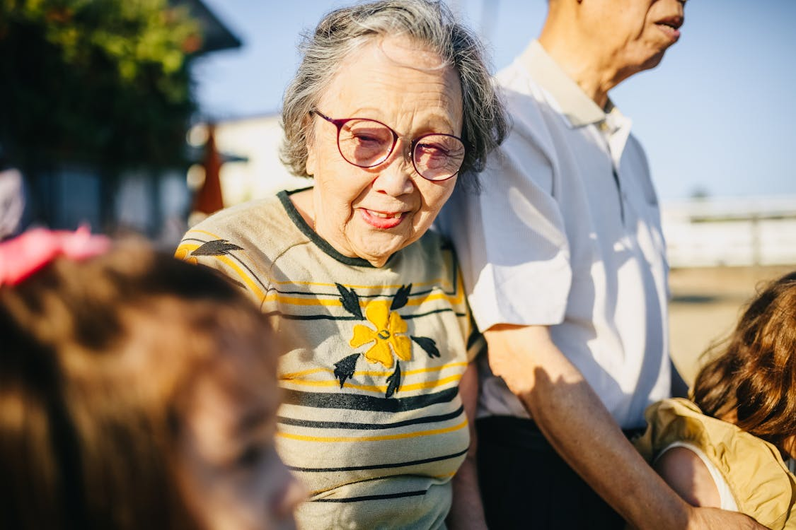 older woman wearing yellow t-shirt with flower