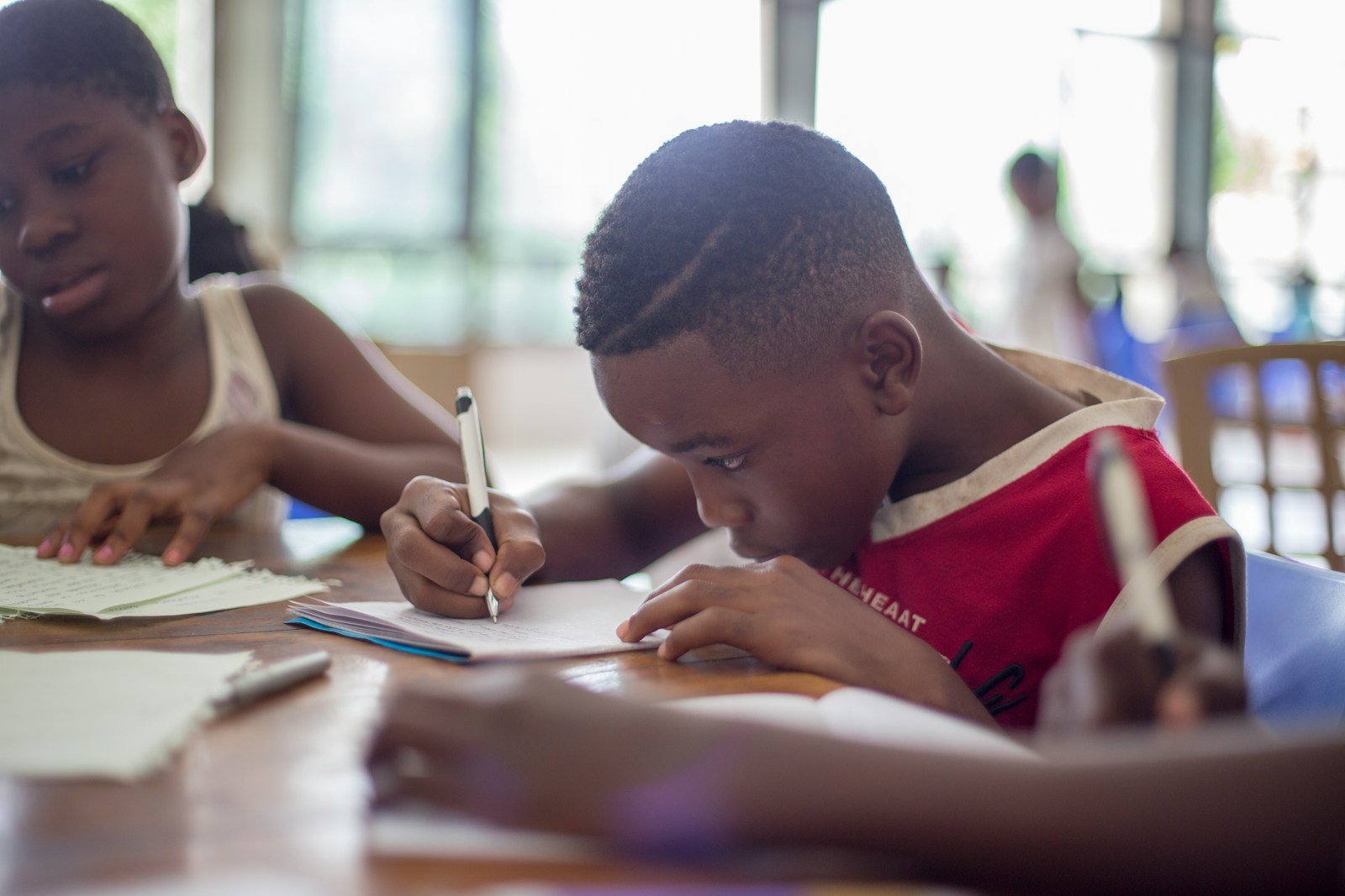 boy writing on paper at school