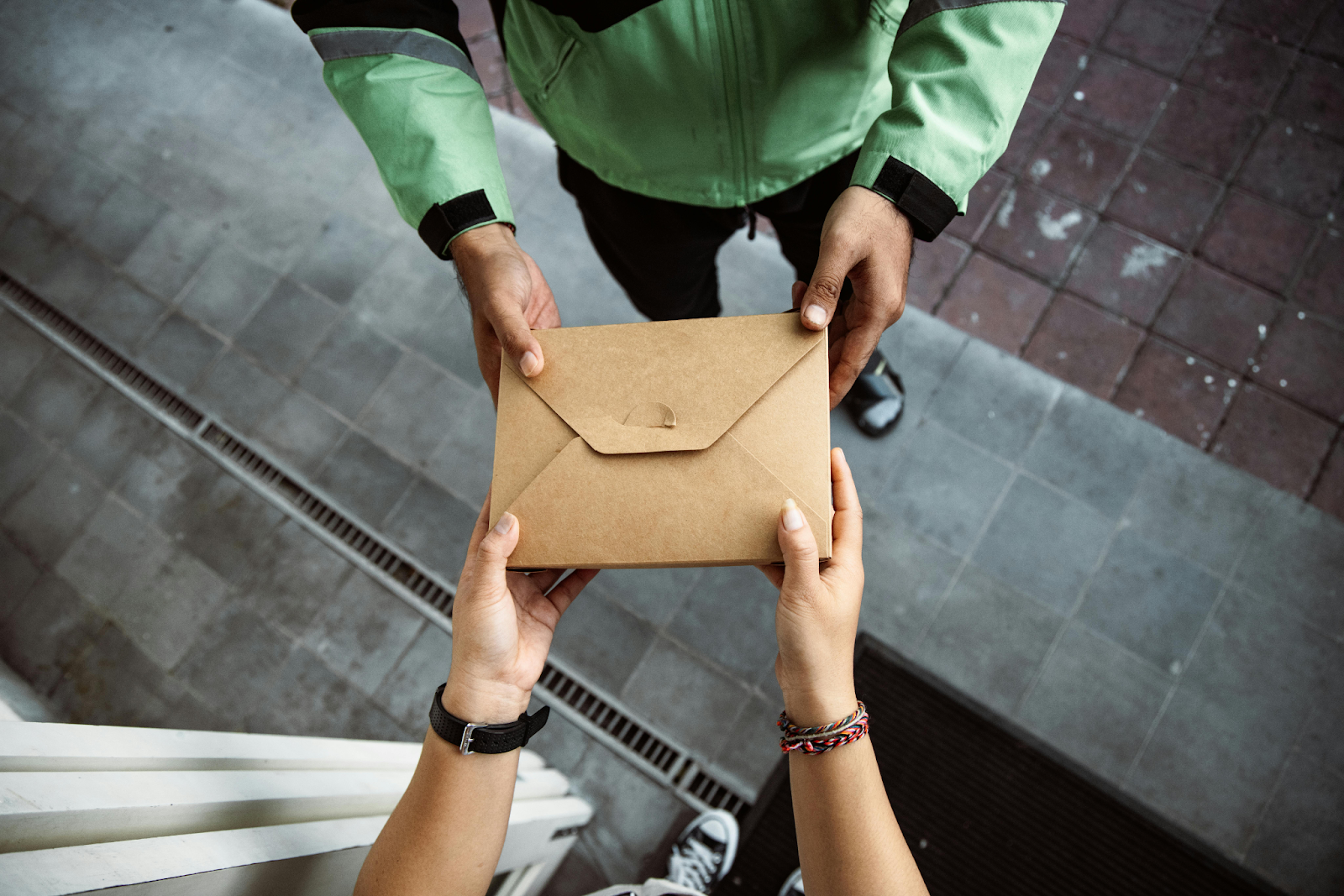delivery driver handed parcel to person at home
