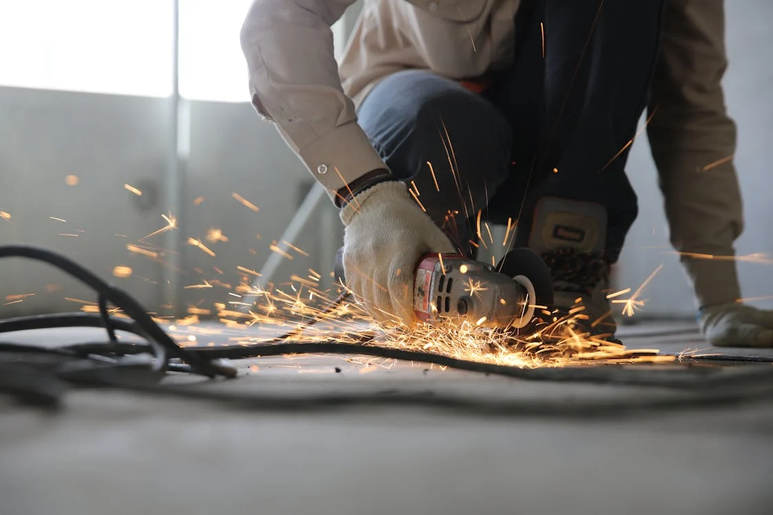 person welding on floor wearing gloves