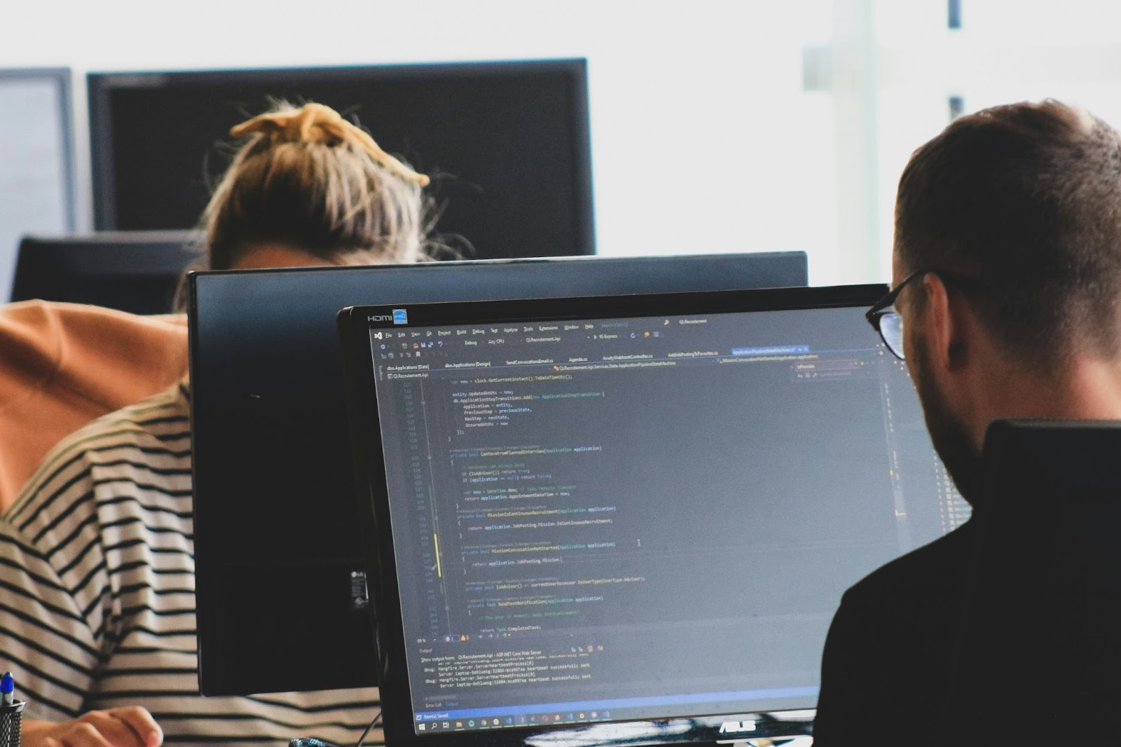 two people sitting at computer screens