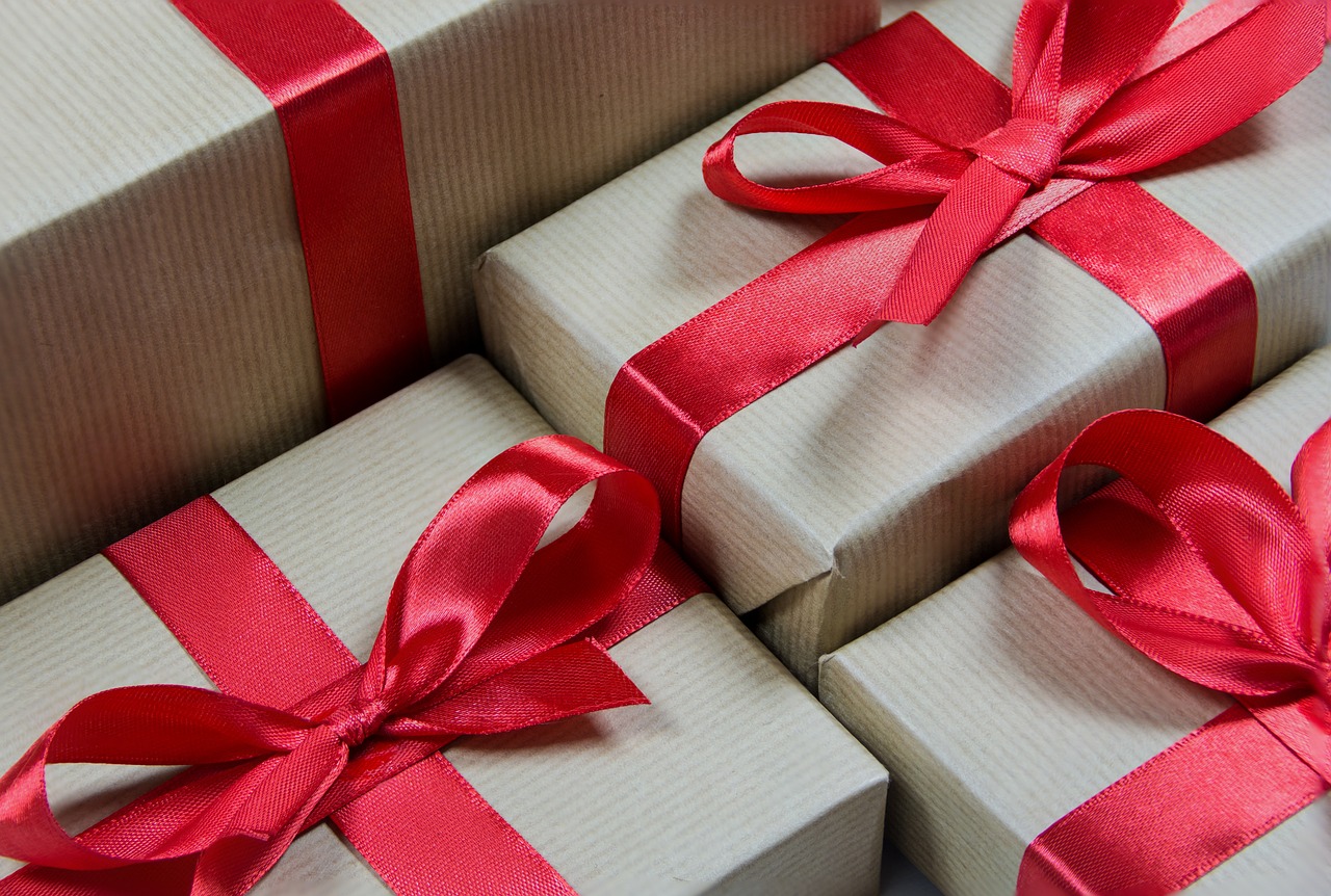 gift wrapped boxes with red ribbons on tied in a bow