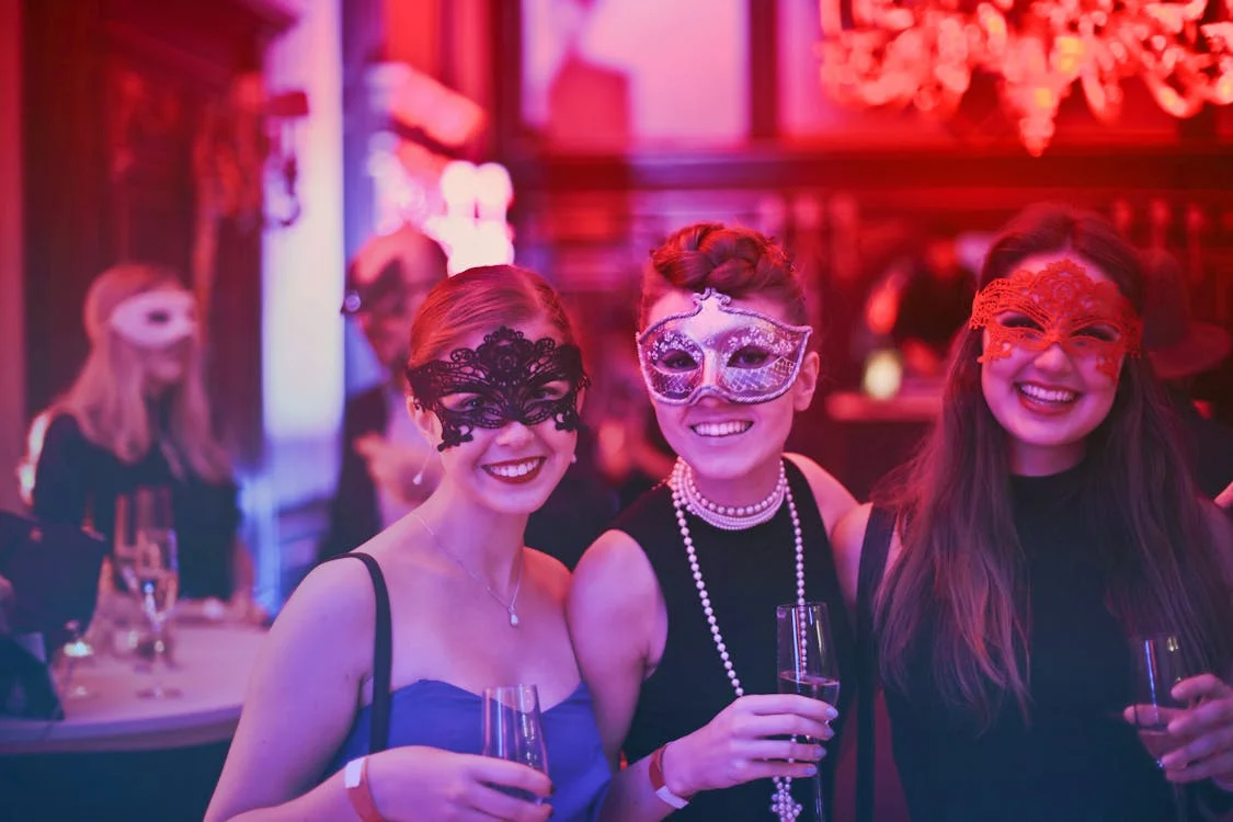 3 women wearing masks, smiling for the camera