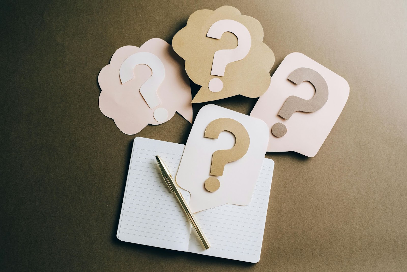 paper questions marks and notepad and pen