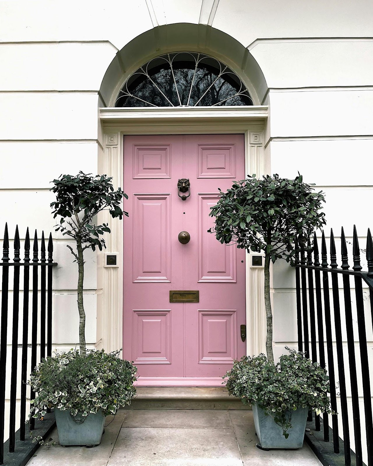 front of house with pink door and knocker