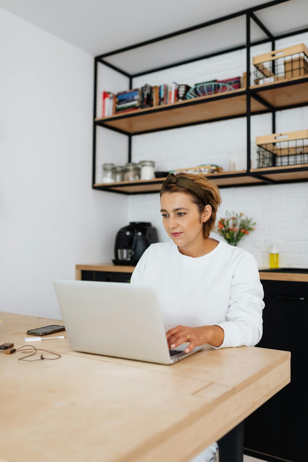 woman wearing headband, sitting at table with laptop