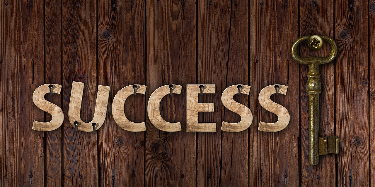 success written in wood nailed to wood surface, with brass key next to it