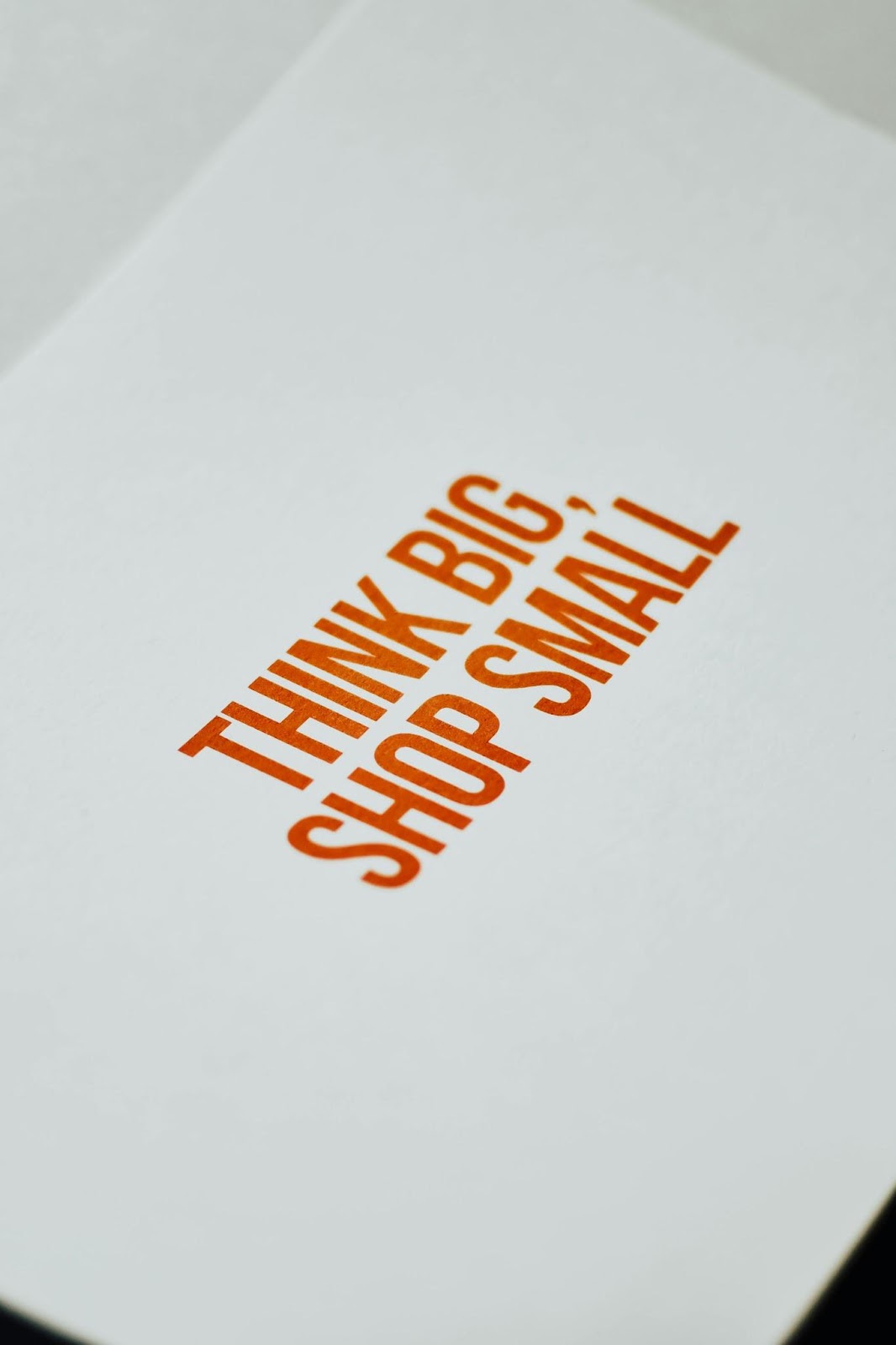 think big, shop small written on paper in red print in capital letters