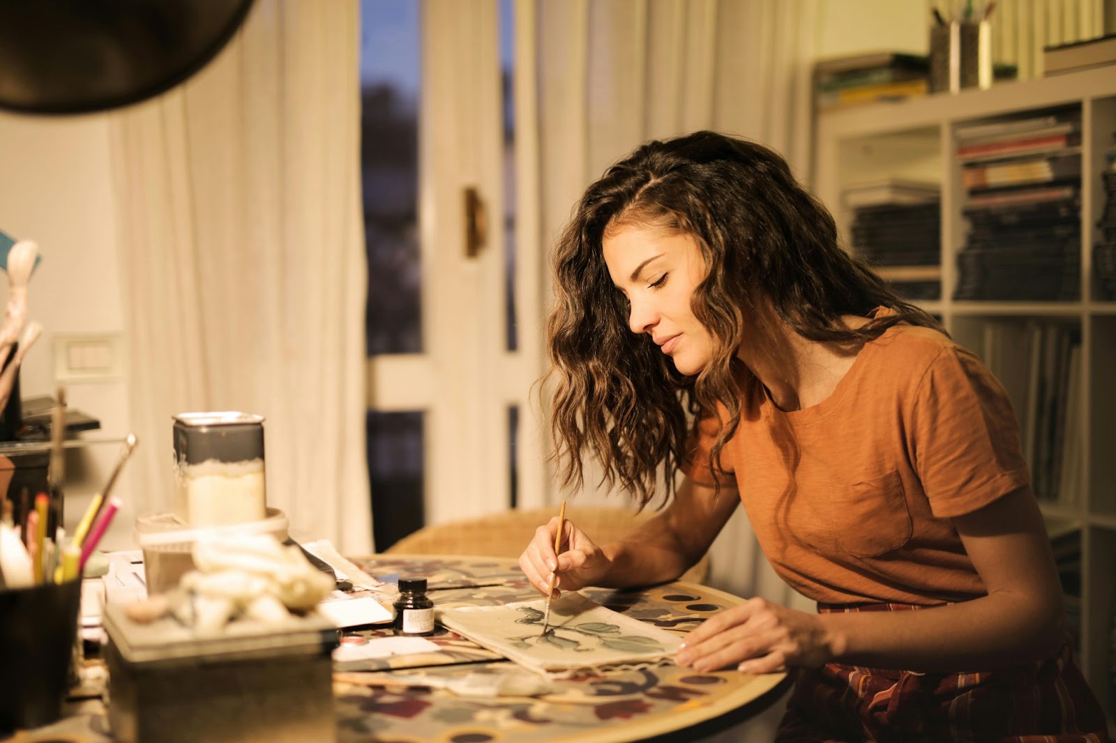 woman sitting at a table in house painting
