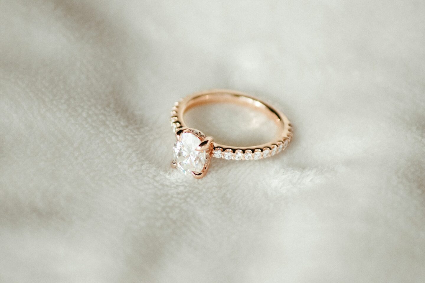 A close up of an engagement ring on a white cloth