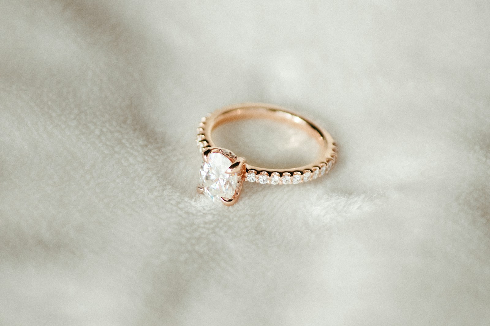 A close up of an engagement ring on a white cloth