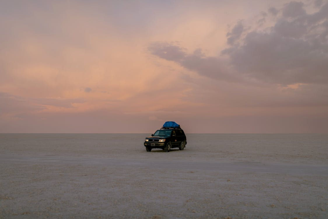 car with roof rack on in middle of dry desert
