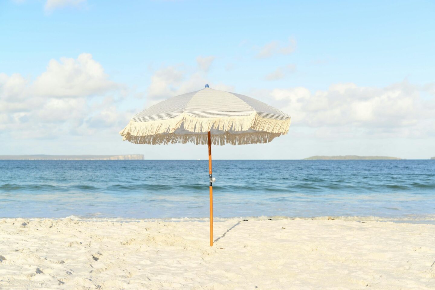 white umbrella on sand on beach
