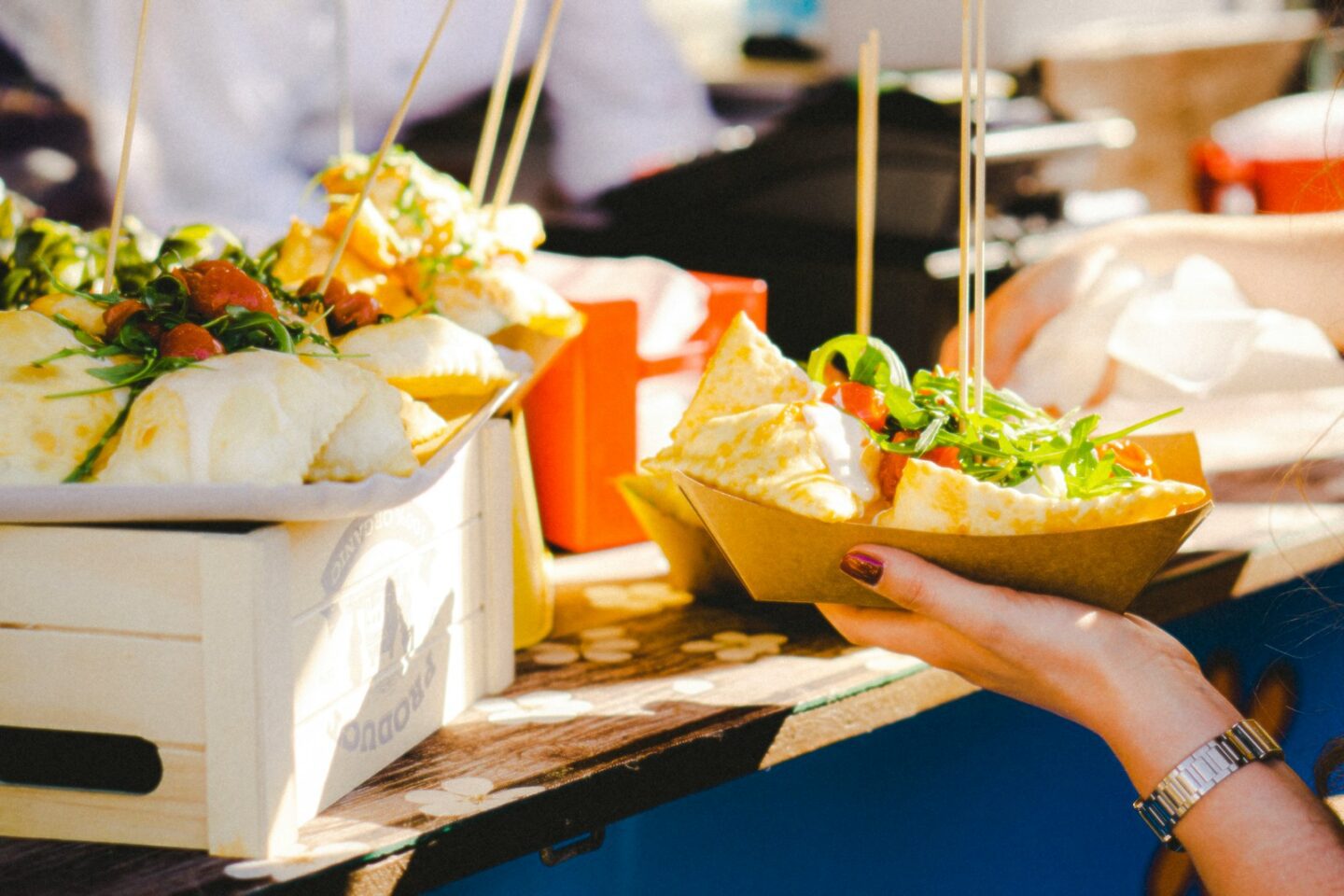 a woman holding a bowl of food at a food truck