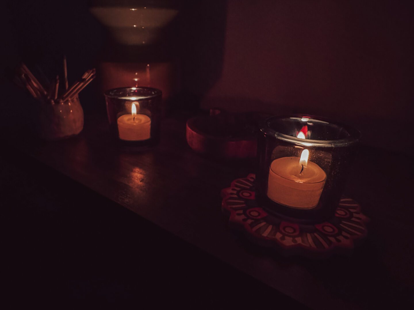 two lit candles on coffee table in low lighting