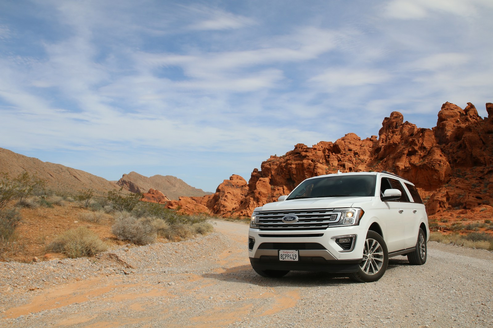 parked white Ford Explorer SUV on a desert road